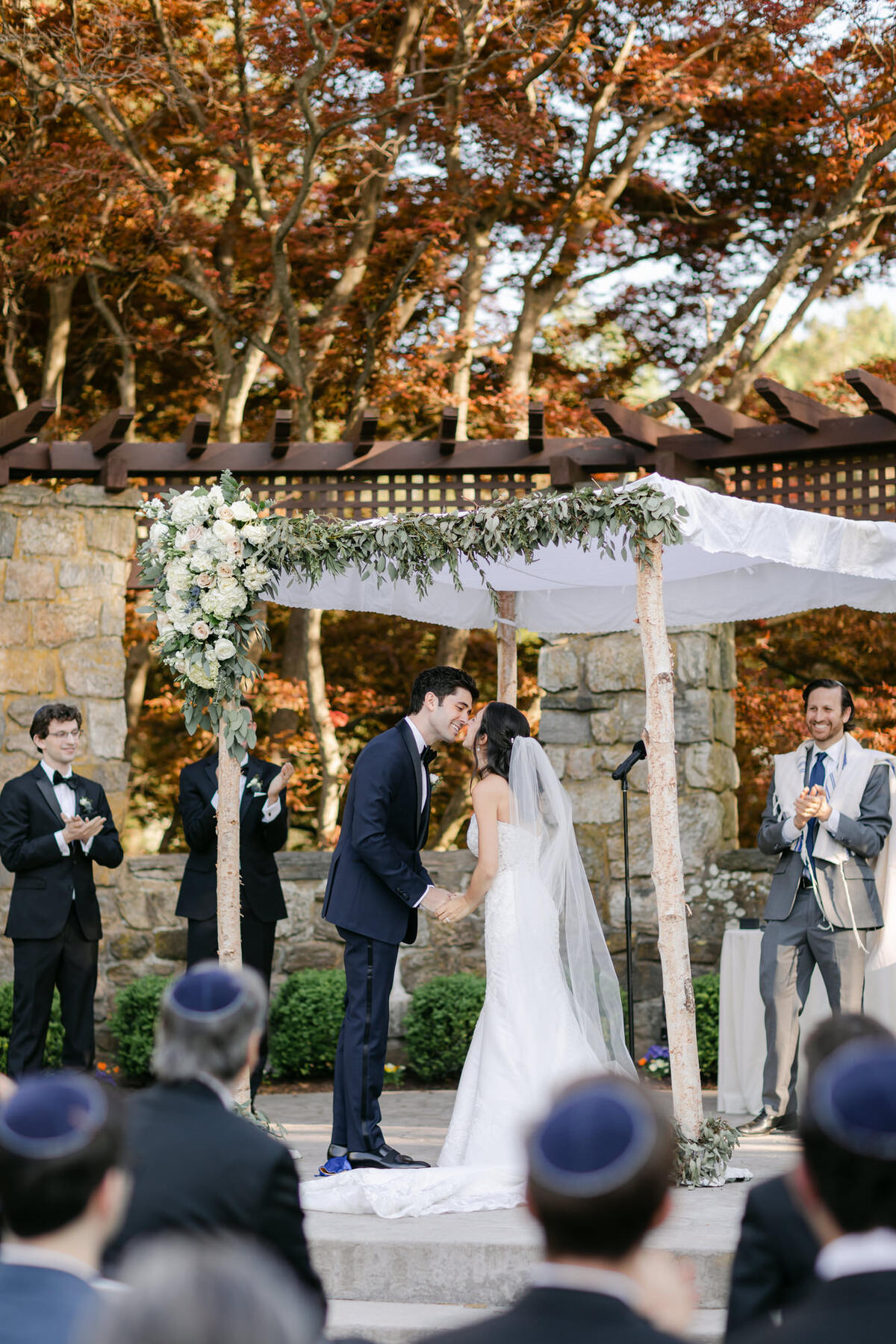 Bride and Groom kissing under the chuppah at Jewish wedding at Le Chateau